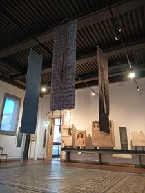 Gli arazzi di Sandra Marconato appesi sopra uno dei mosaici del Museo Eremitani di Padova