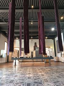 Gli arazzi di Sandra Marconato appesi sopra uno dei mosaici del Museo Eremitani di Padova